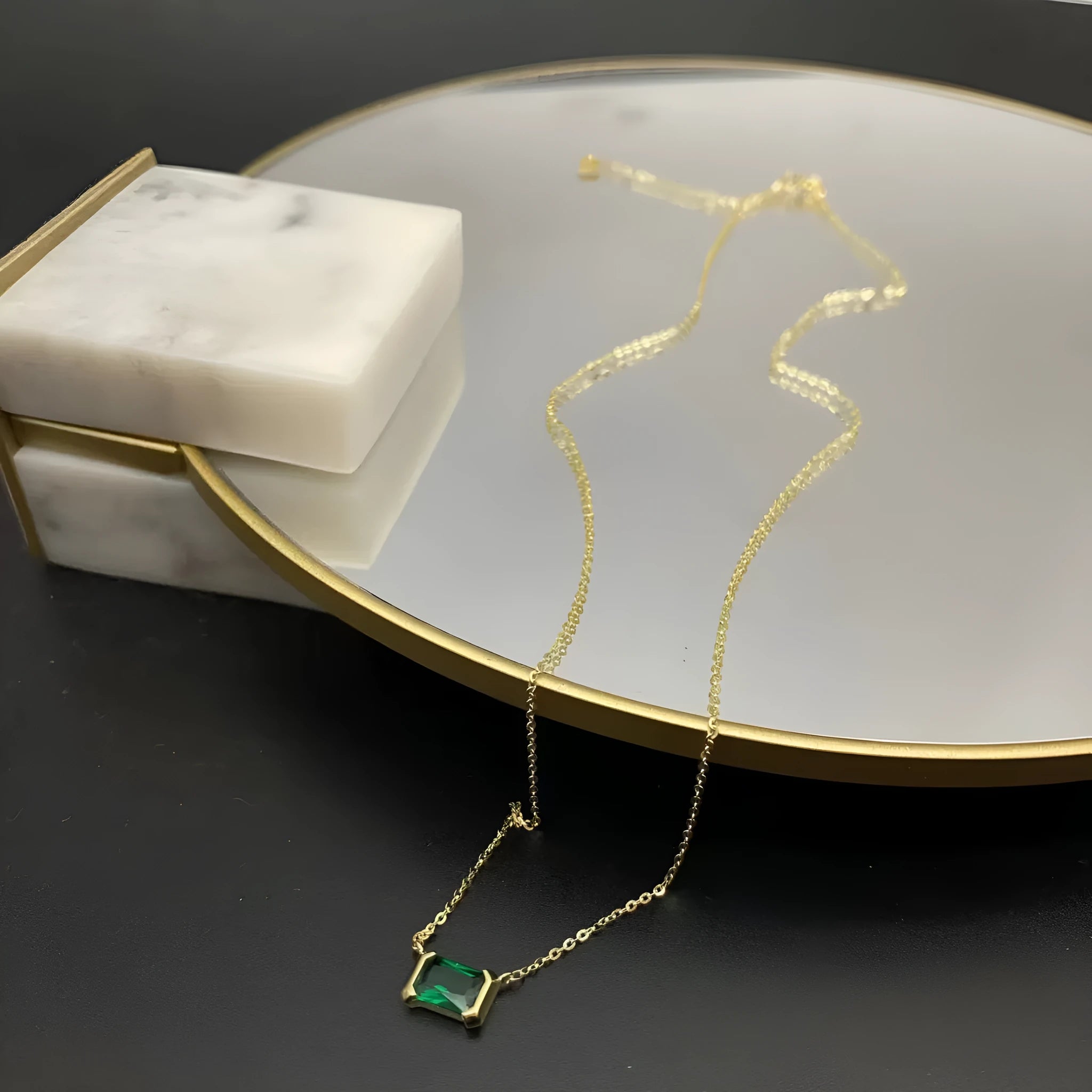 Gold geometric quadrilateral pendant necklace with inlaid cubic zirconia stones on a matching chain.