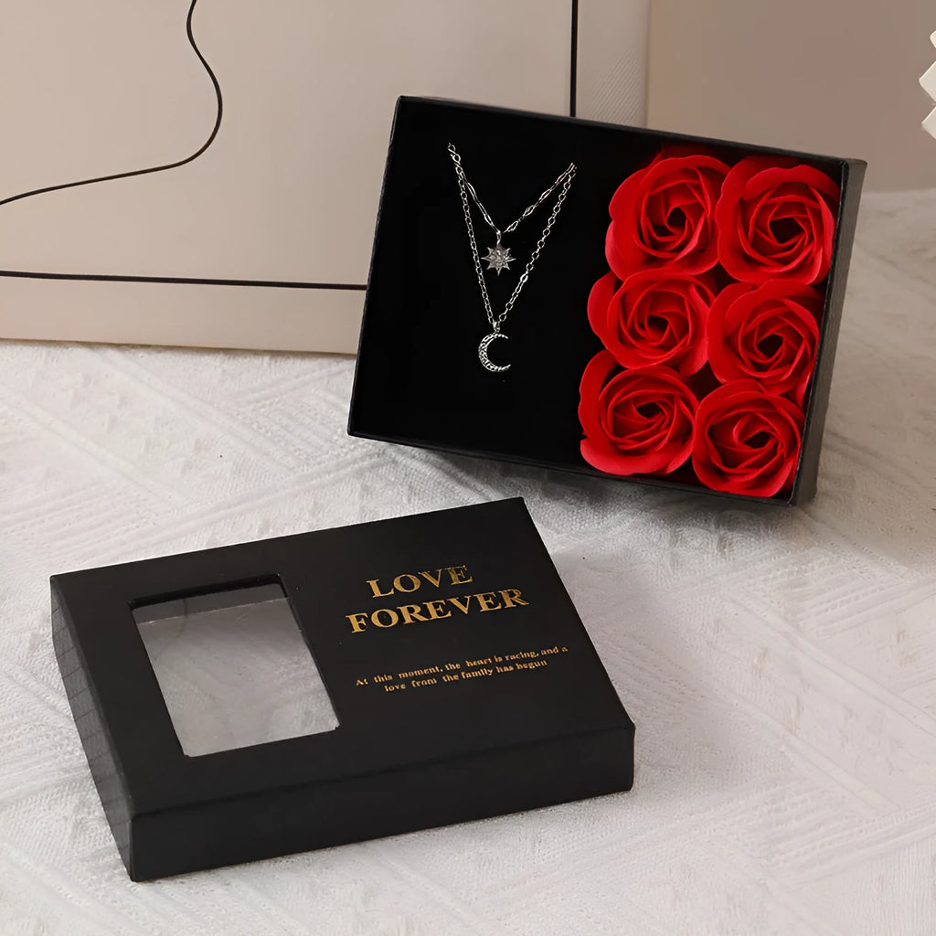 Red Valentine's gift box containing six pink soap flowers, with a matching red handbag alongside.