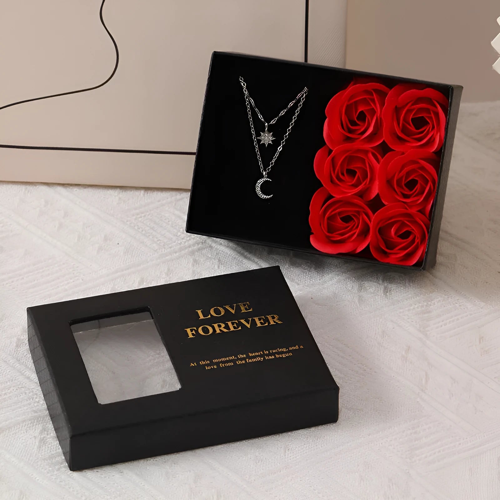 Red Valentine's gift box containing six pink soap flowers, with a matching red handbag alongside.