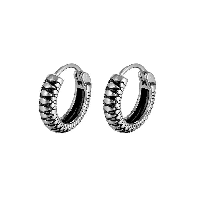 A pair of silver geometric twist earrings made from stainless steel alloy on a white background.