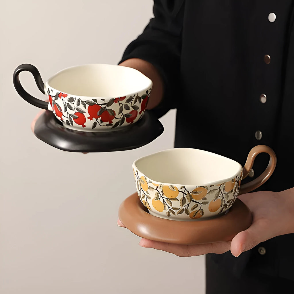 Antique style ceramic coffee cup and saucer with 210ml capacity, shown in black pomegranate and orange Citrofortunella design options.