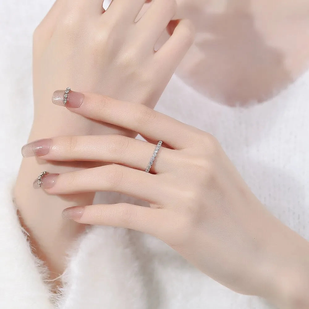Women's open mouth geometric ring with a diamond tail, in white gold colour on a model's hand.