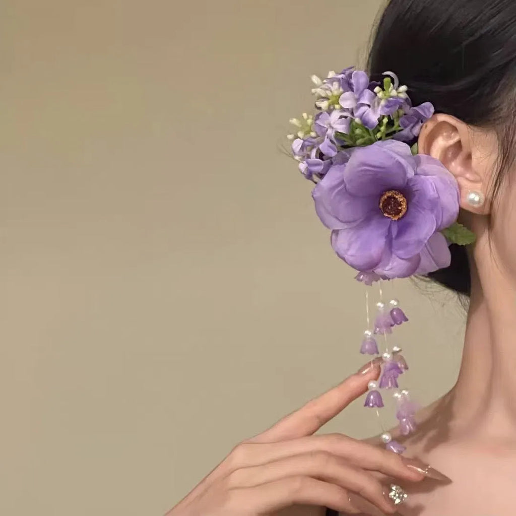 Hand-made yellow and purple flower tassel hair clip with pearl accents on a white background.