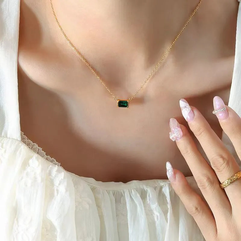 Gold geometric quadrilateral pendant necklace with inlaid cubic zirconia stones on a matching chain.