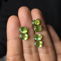 Close-up of grass green natural olivine stud earrings in S925 sterling silver setting.