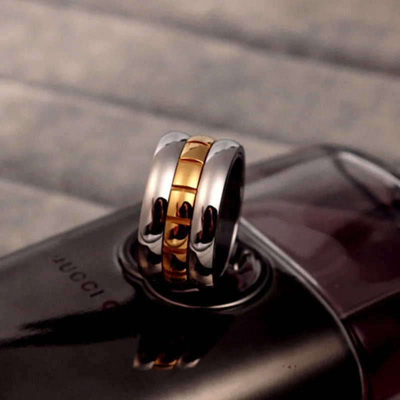 Gold titanium steel ultra-wide knuckle ring with a rotatable tail, shown on a finger.