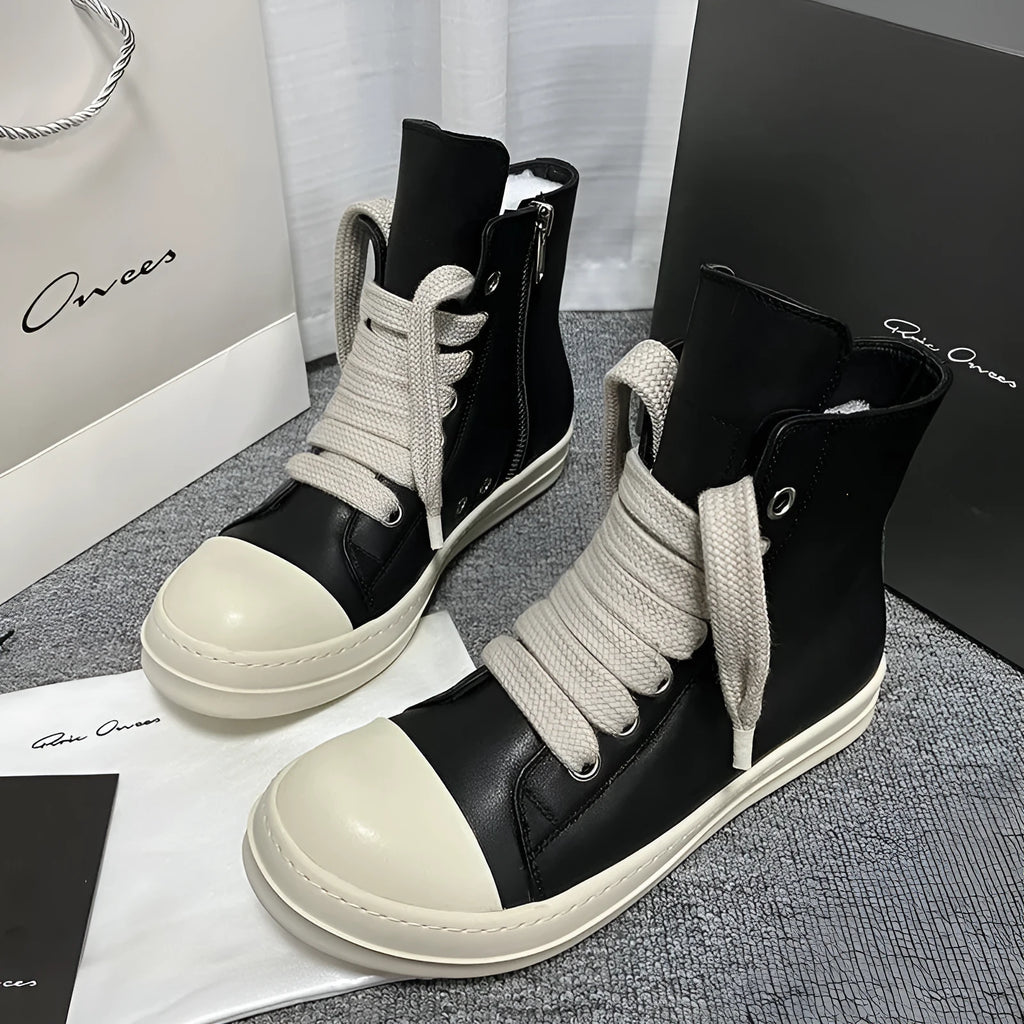 Black high-top genuine leather boots with side zip detail on a white background.