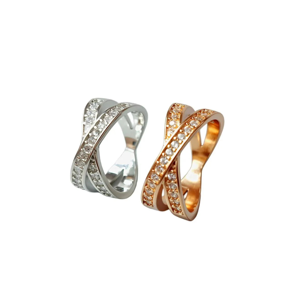 Geometric cross metal ring with micro-inlaid zircon stones, shown in silver and rose gold finishes.