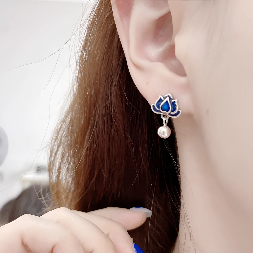 Silver-tone blue lotus flower stud earrings with a dangling seedpod tassel.