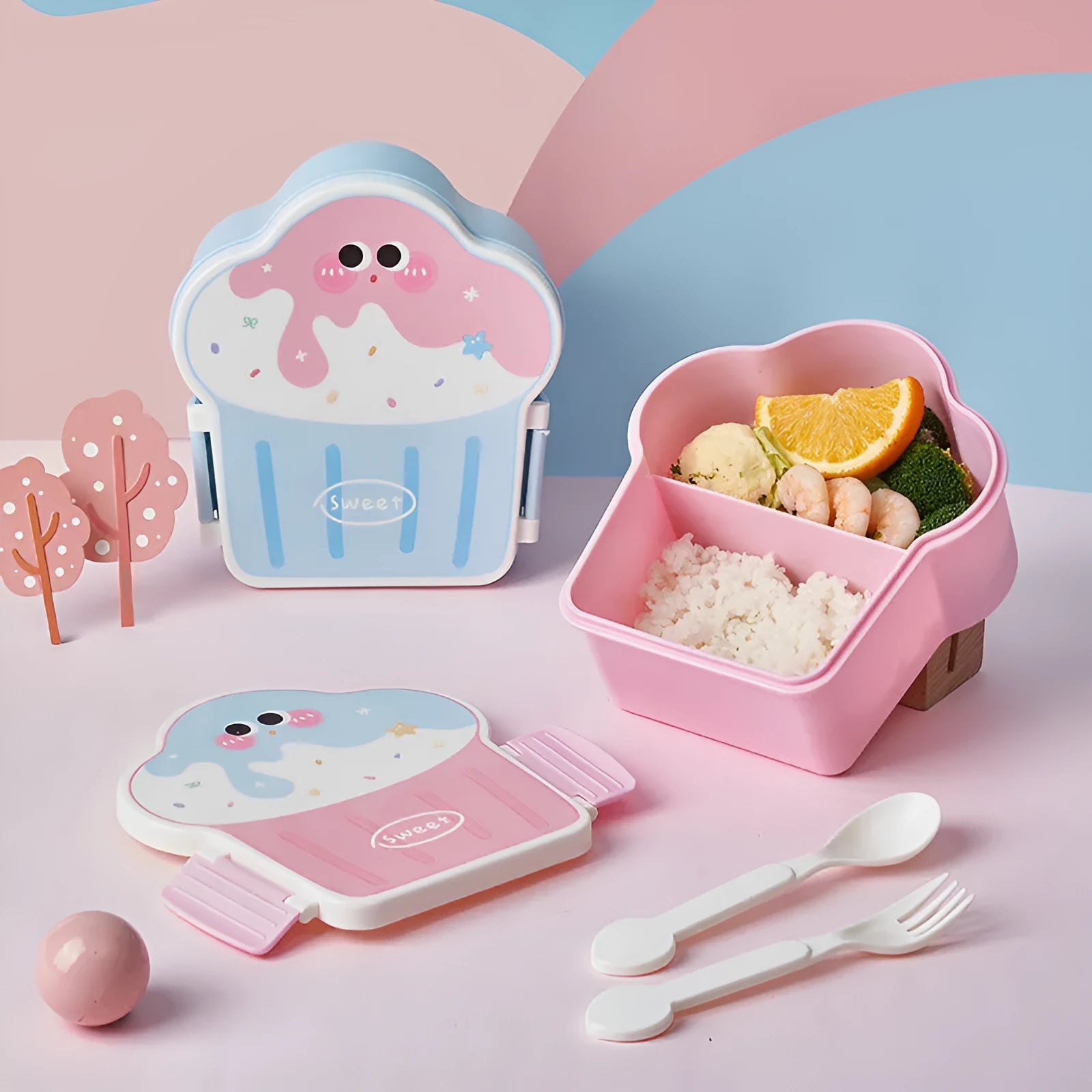 Pink and blue creative ice cream shaped plastic lunch boxes with spoons and forks on a plain background.
