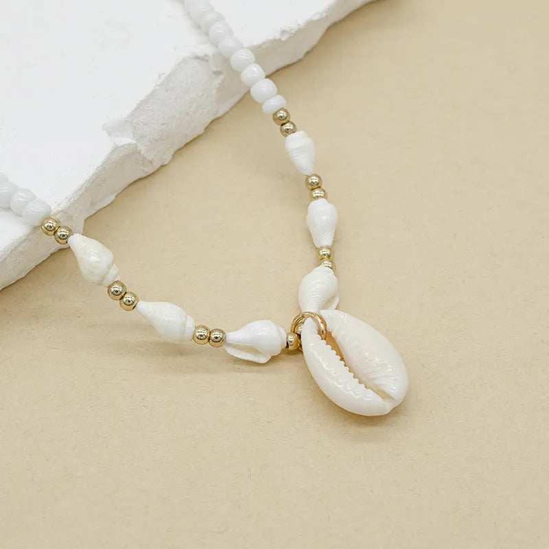 White electroplated conch shell pendant necklace on a regular chain for women.
