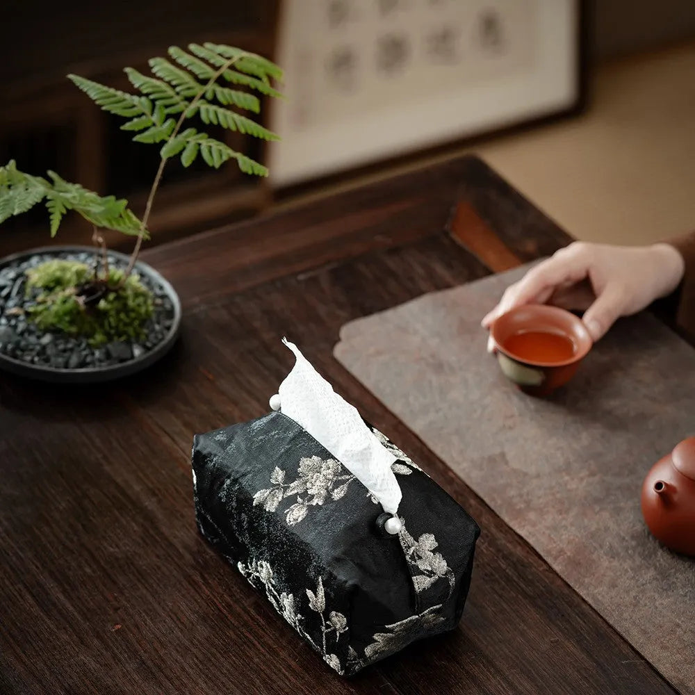 White Chinese brocade tissue box cover with embroidered plum blossoms, showing pearl buckle and plain opening options.
