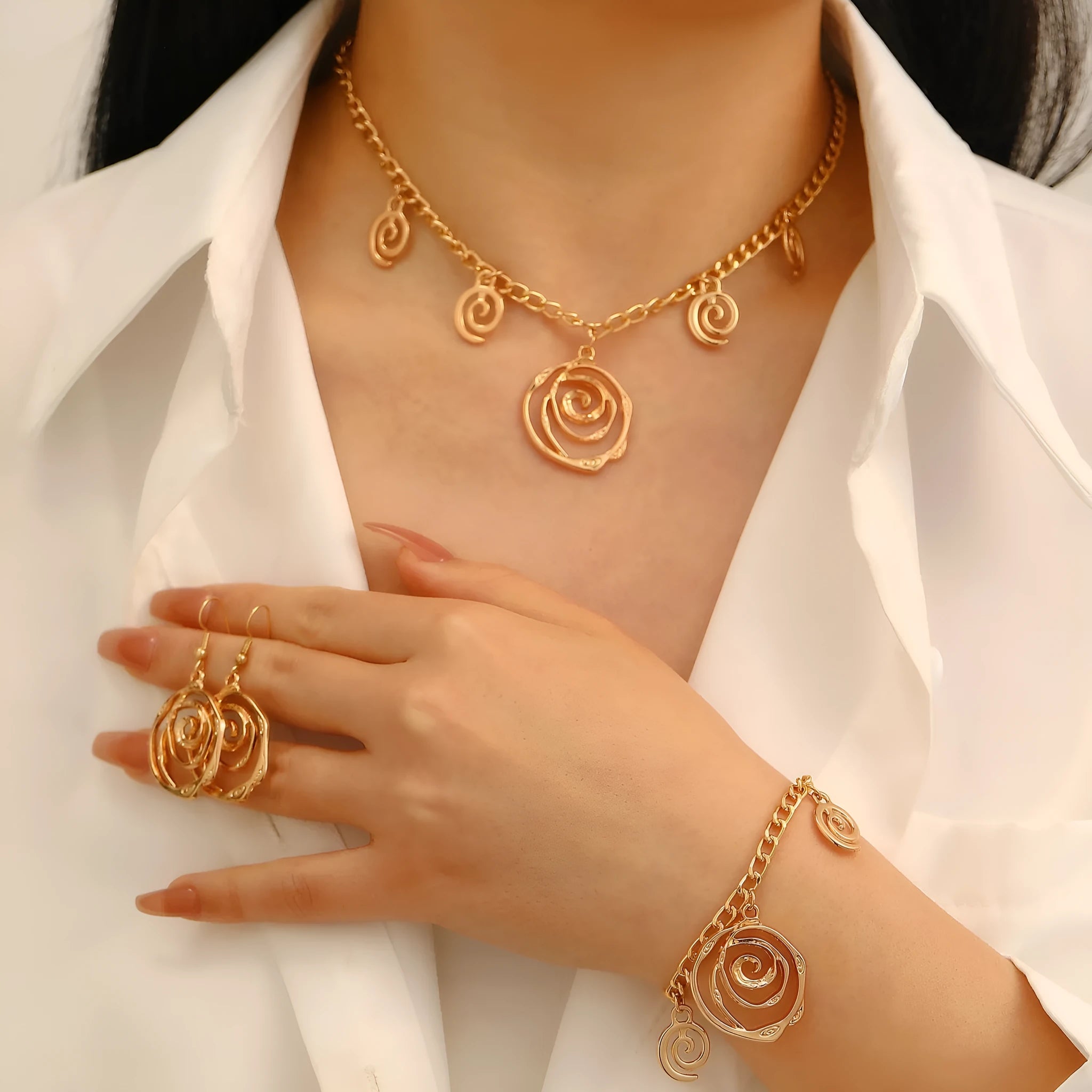 Spiral donut design jewellery set with necklace, bracelet and ear hooks in gold or silver finish