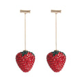 Geometric strawberry shaped zinc alloy earrings with spot drill texture on a red background.