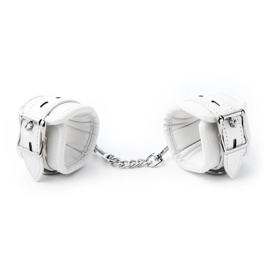 White PU sponge bondage set showing handcuffs, foot cuffs, and a neck scarf for adult play.