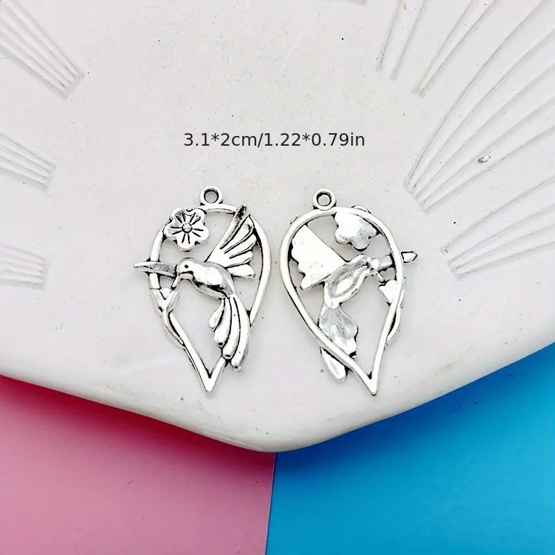 Close-up of a silver-coloured alloy pendant shaped like a magpie bird with detailed feathers, on a white background.