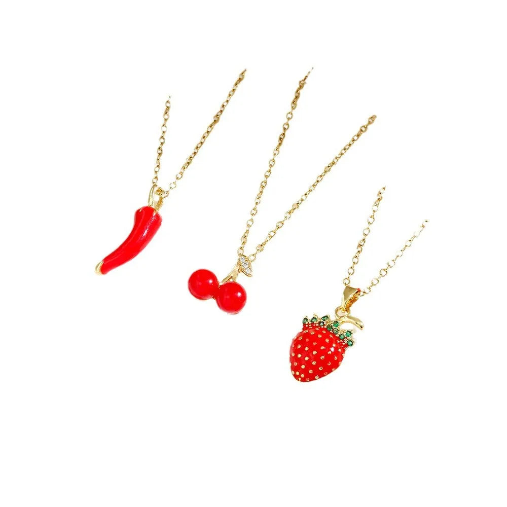 Delicate red fruit charm necklace on a titanium steel O-ring chain, showing gold and steel colour options.