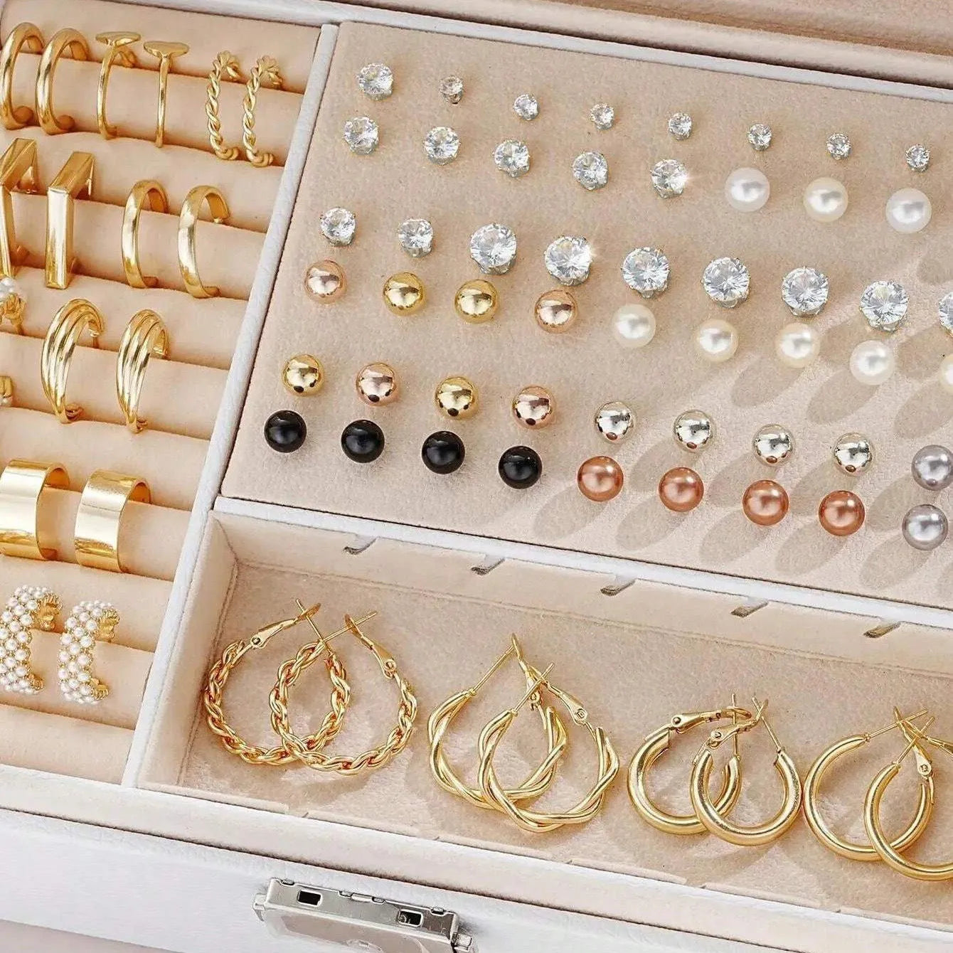 108 gold and yellow geometric alloy earrings with pearl details laid out flat.