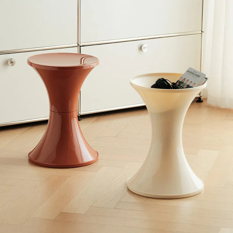 Green plastic hourglass-style shoe changing stool on a wooden floor.