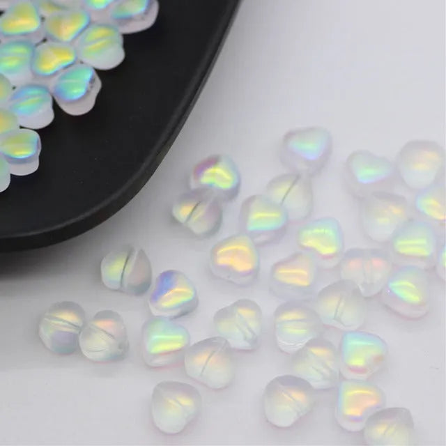 Twenty transparent Czech glass love heart spacer beads in assorted colours including aurora purple and peach gold.