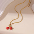A women's necklace with a detailed strawberry-shaped alloy pendant on a stainless steel chain, shown in red and white gradient colour options.