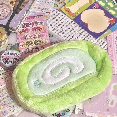 Honeydew roll plush velvet pencil case in Swiss roll cake colour on a desk.