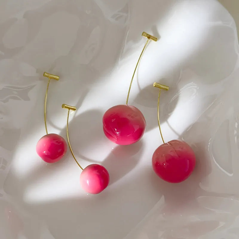 Pair of peach-shaped acrylic fashion earrings with copper posts on a white background.