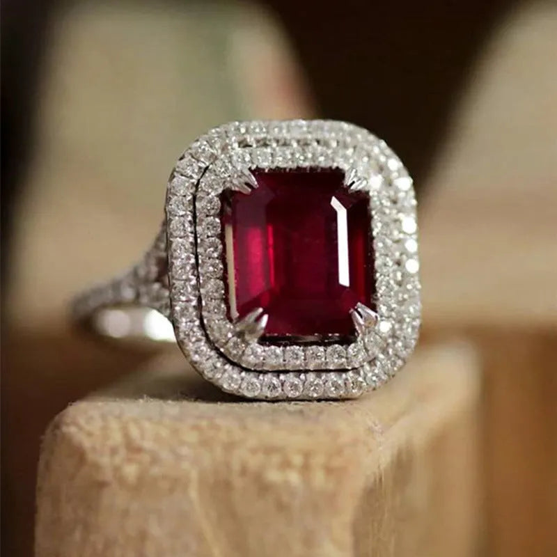 Women's geometric copper ring with a square red rhinestone on a hand.