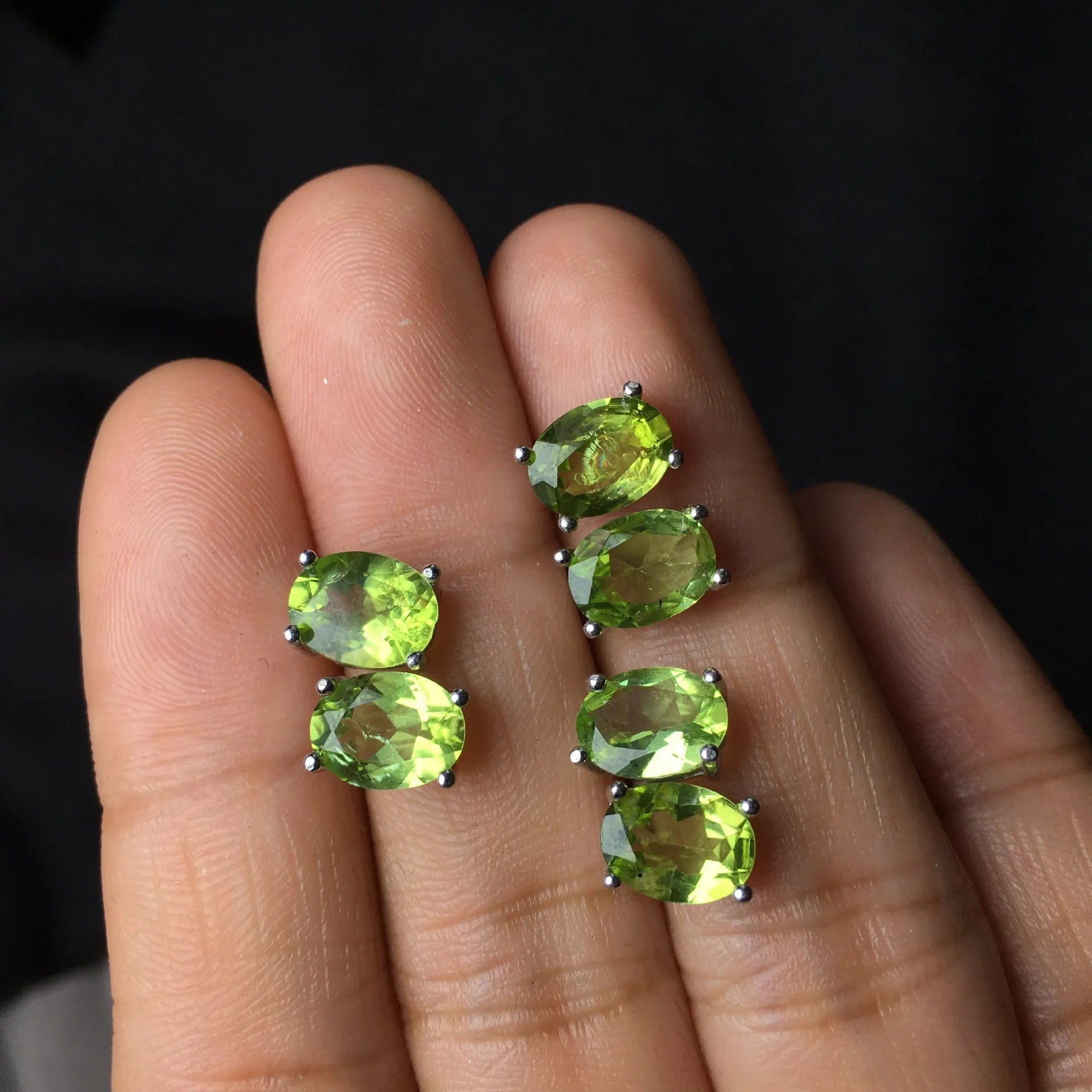 Close-up of grass green natural olivine stud earrings in S925 sterling silver setting.