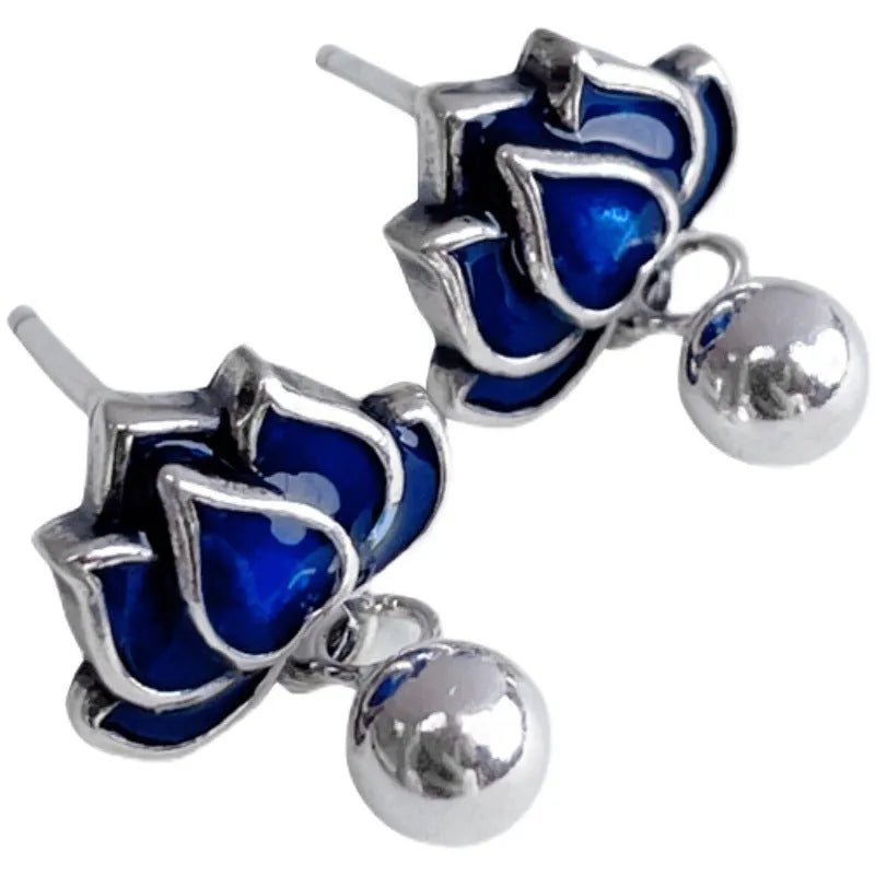 Silver-tone blue lotus flower stud earrings with a dangling seedpod tassel.