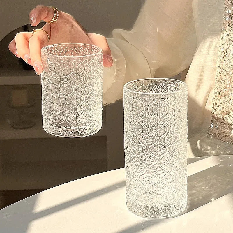 Begonia patterned glass drinking cup in short and tall sizes on a table.