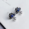 Silver-tone blue lotus flower stud earrings with a dangling seedpod tassel.