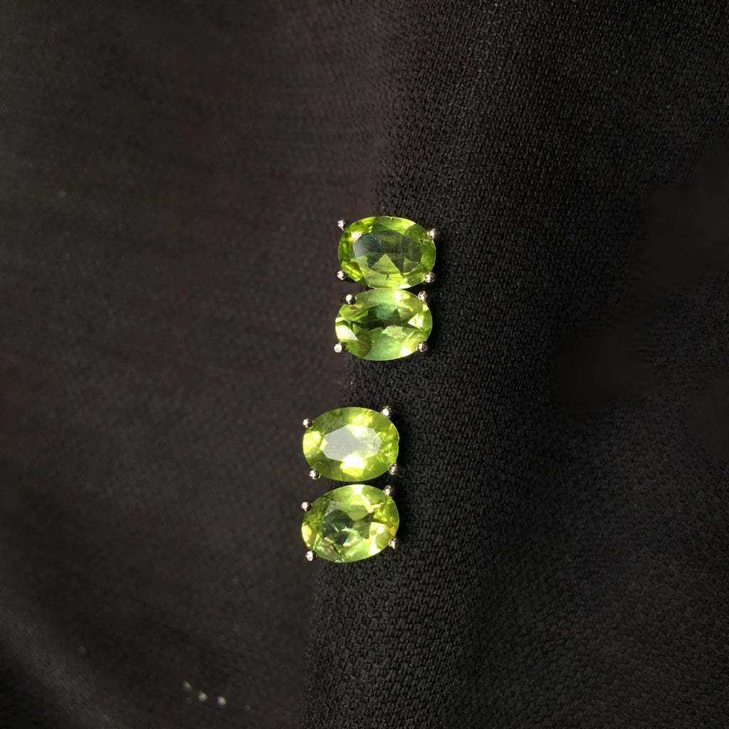 Close-up of grass green natural olivine stud earrings in S925 sterling silver setting.