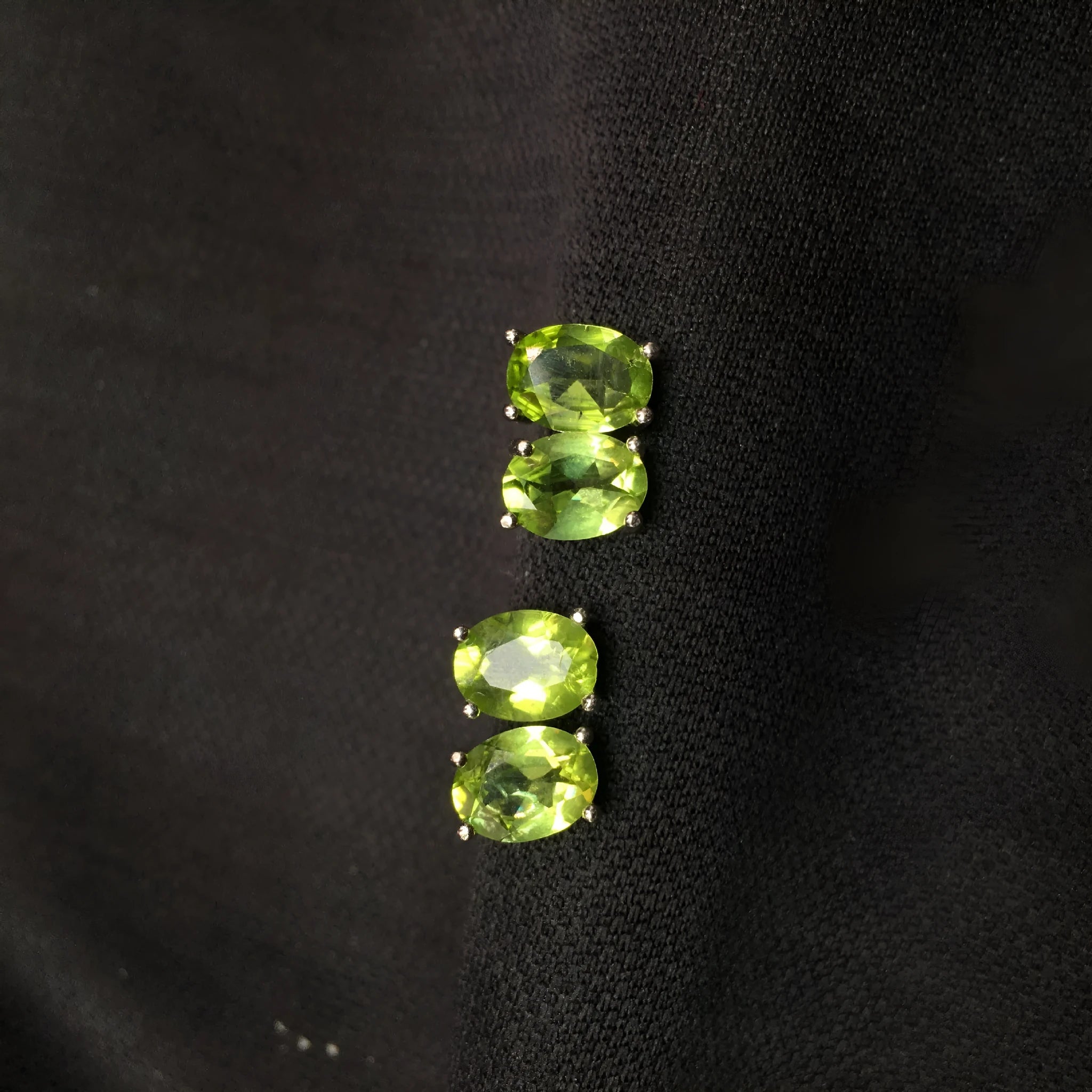 Close-up of grass green natural olivine stud earrings in S925 sterling silver setting.