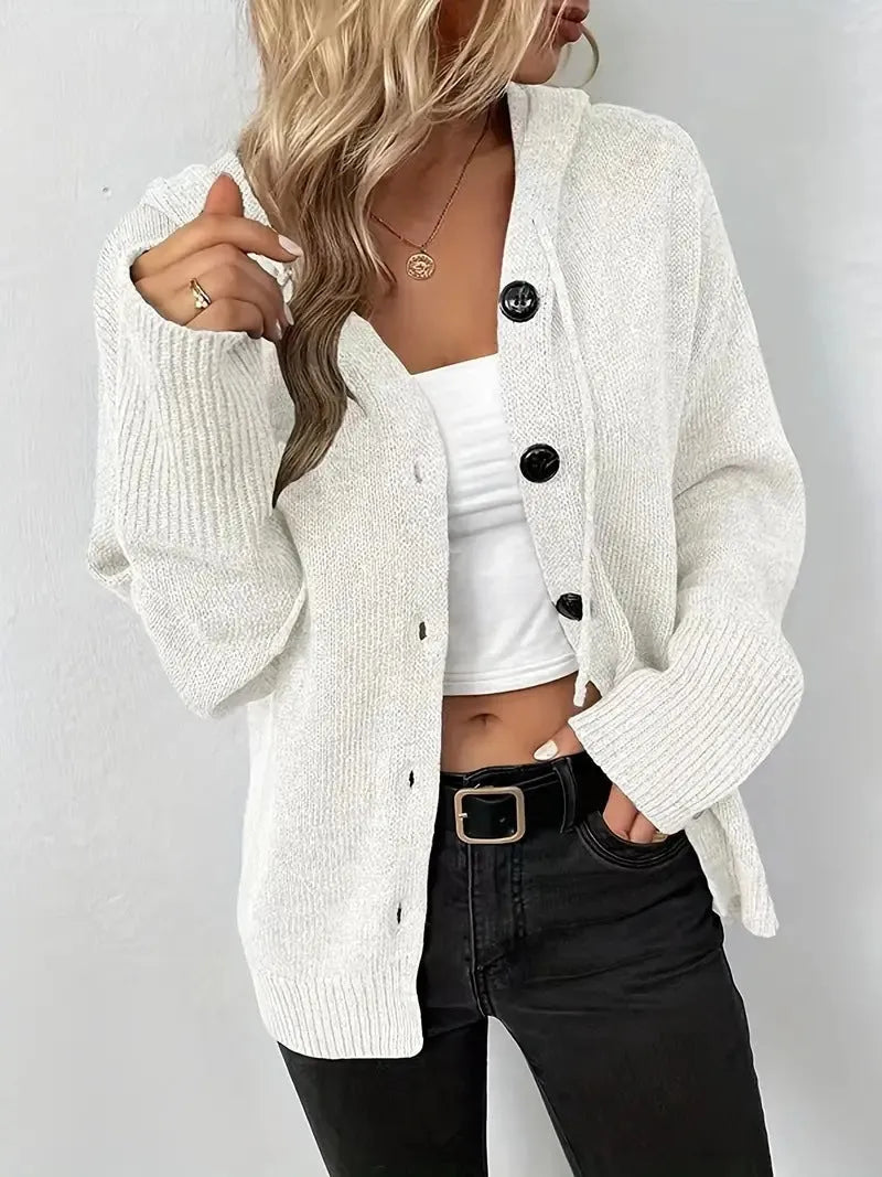 Solid colour hooded cotton cardigan sweater with loose fit and long sleeves on a hanger.
