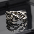 Copper men's ring with geometric thorn and flower design on an adjustable band