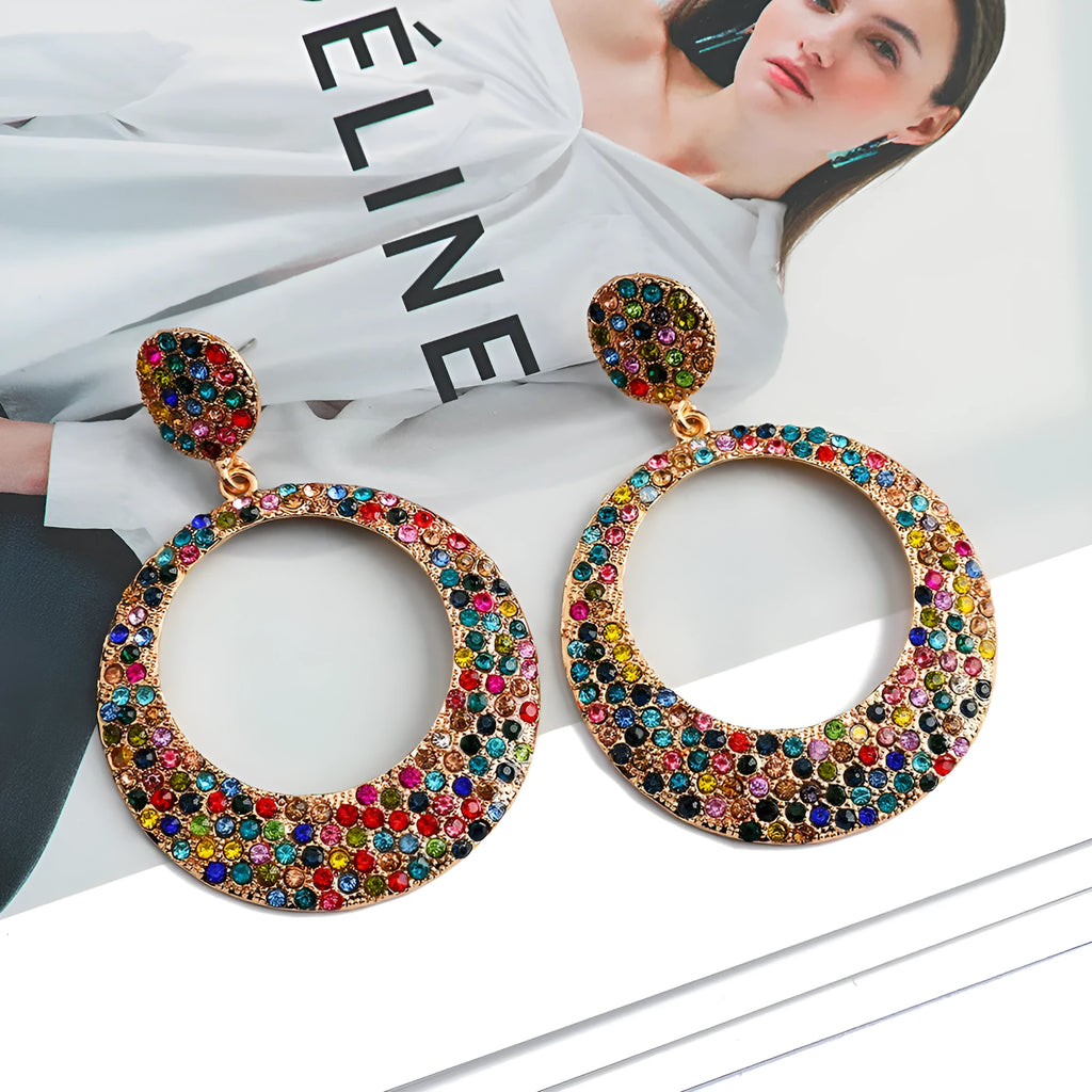 A pair of large round pendant earrings with a cartoon style in a colour metal alloy finish.