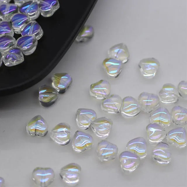 Twenty transparent Czech glass love heart spacer beads in assorted colours including aurora purple and peach gold.