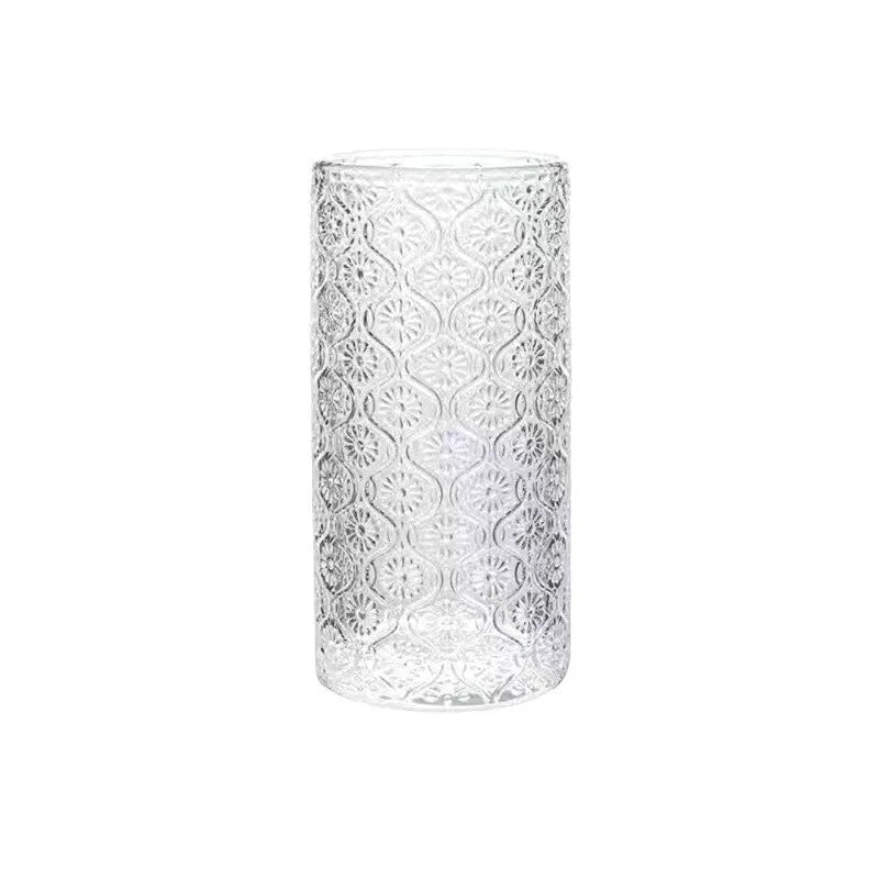 Begonia patterned glass drinking cup in short and tall sizes on a table.