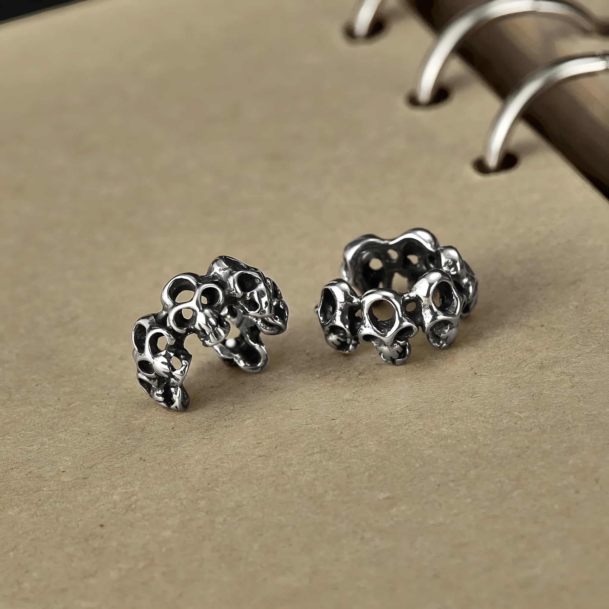 Stainless steel skull earrings with hollow geometric design and clip-on style
