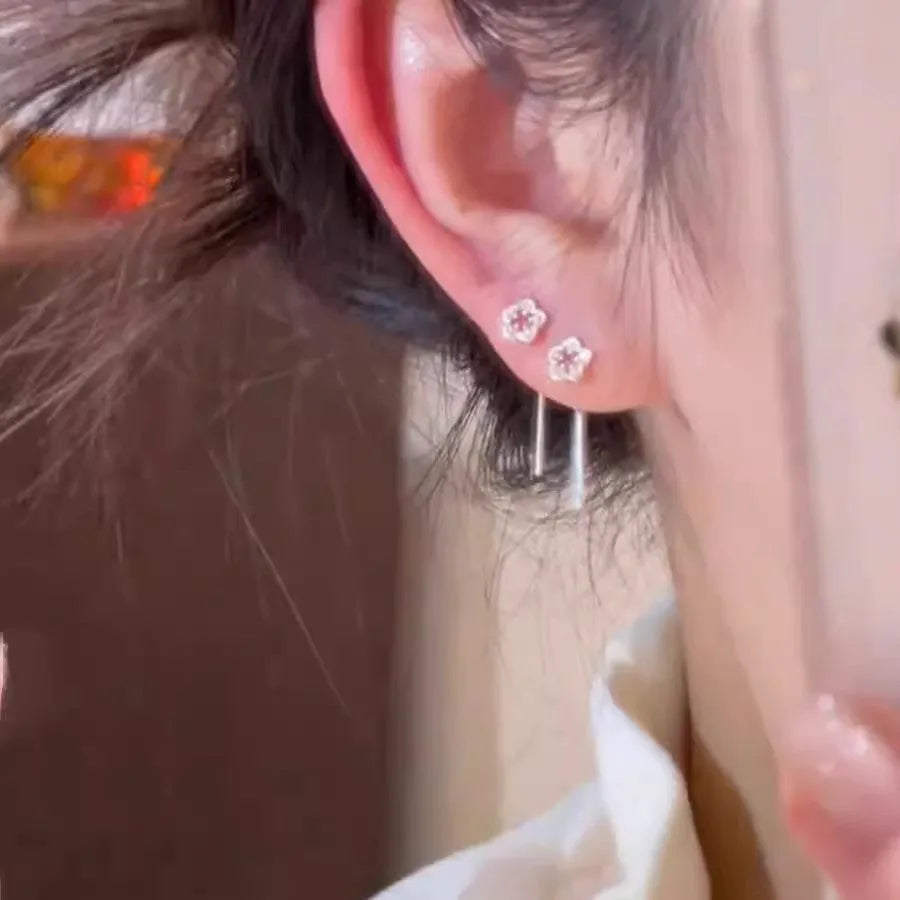Silver hollow flower hanging earrings with petal detailing and needle fastening