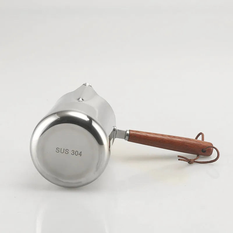 Stainless steel coffee cup with wooden handle and visible millilitre scale markings.