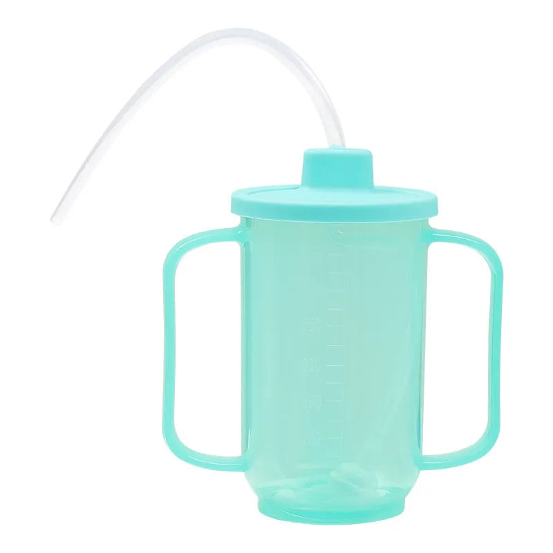 A white PP plastic choke-proof drinking cup with an angled spout, handle, and lid, shown on a bedside table.