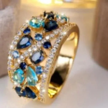 Women's round hollow copper fashion ring on a hand, showing gold and platinum finish options with blue and white accents.