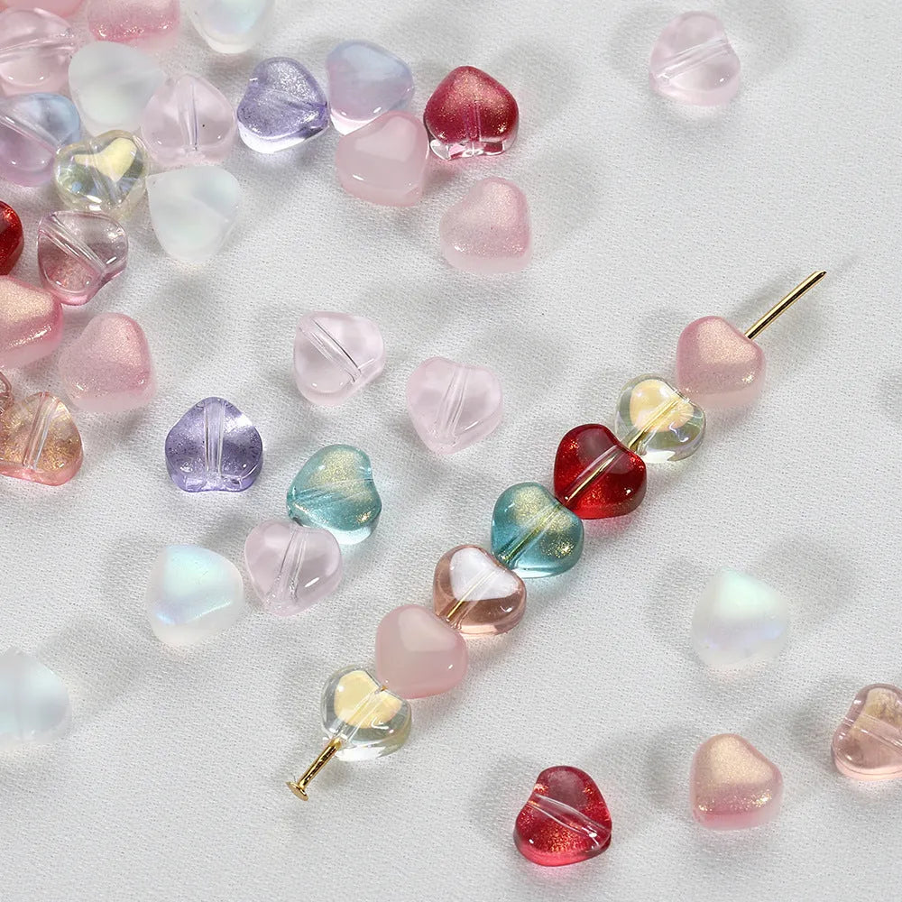 Twenty transparent Czech glass love heart spacer beads in assorted colours including aurora purple and peach gold.