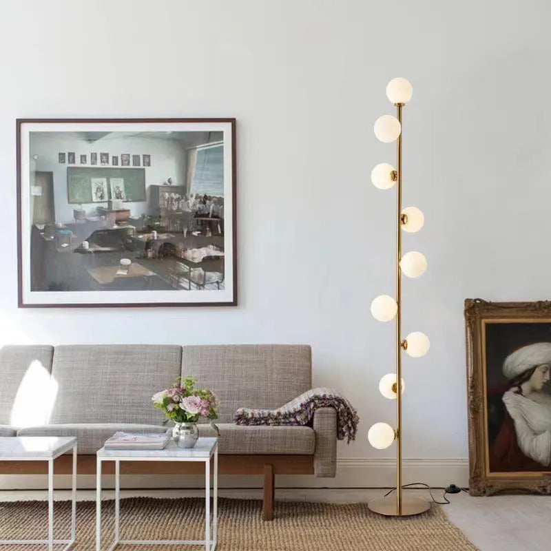 Tall minimalist Nordic floor lamp with wrought iron stem, glass fittings, and a circular white marble base.