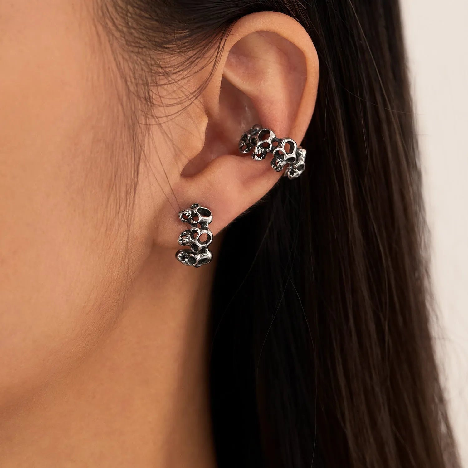 Stainless steel skull earrings with hollow geometric design and clip-on style
