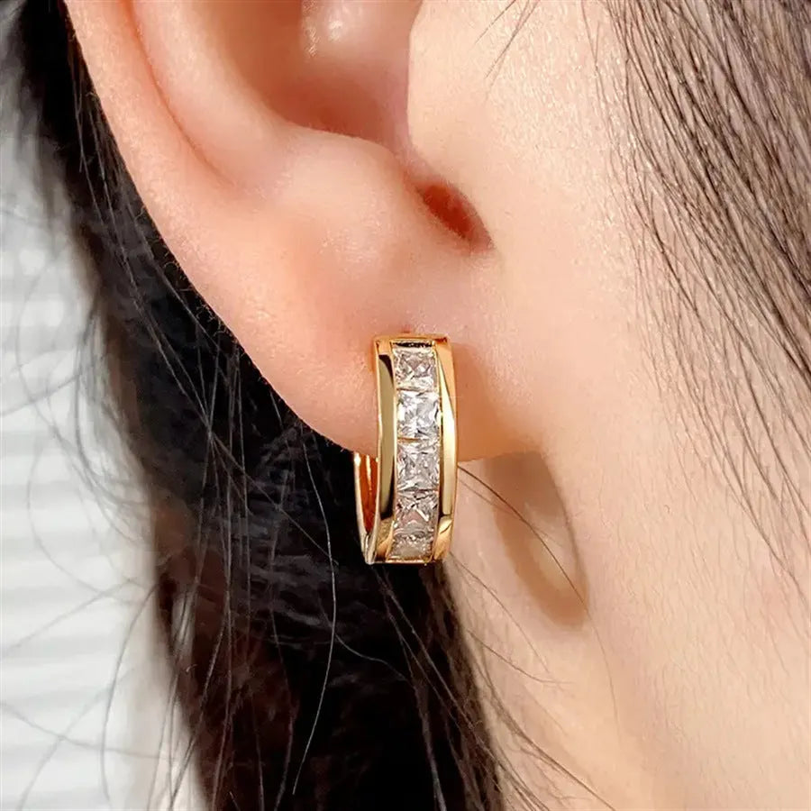 A pair of geometric quadrilateral earrings for women in a gold finish, made from copper.