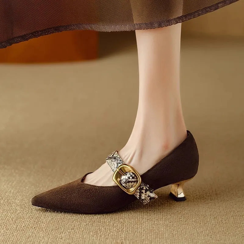 Women's black pointed-toe stiletto heels with an ankle buckle on a rubber sole