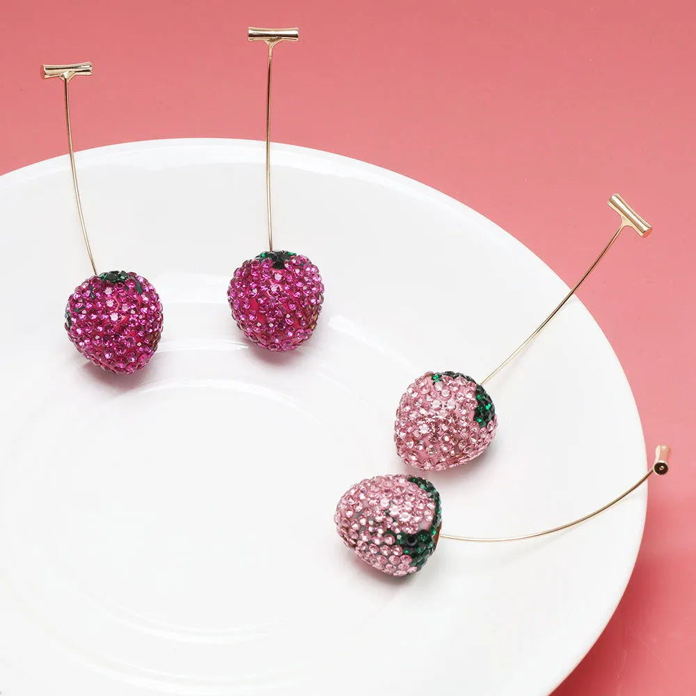 Geometric strawberry shaped zinc alloy earrings with spot drill texture on a red background.